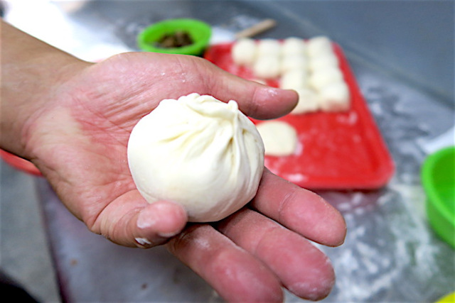 The chef of Uncle A-Shui’s Steamed Buns presents a freshly handmade pork bun