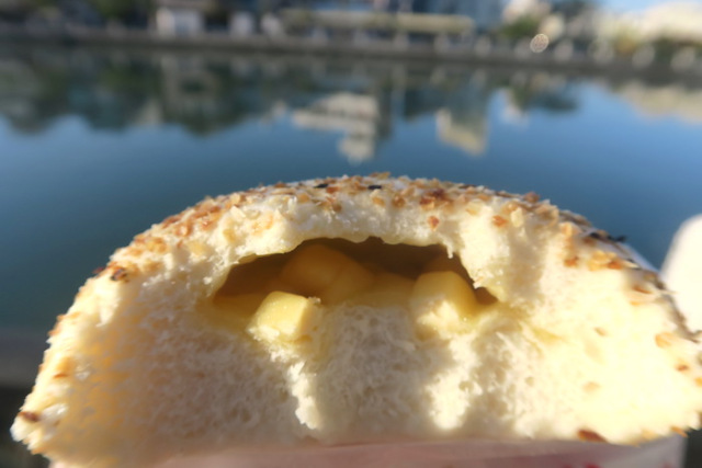 A view of the inside of a Steamed Cheese Bun by Uncle A-Shui's Traditional Bun store by a river in Tainan