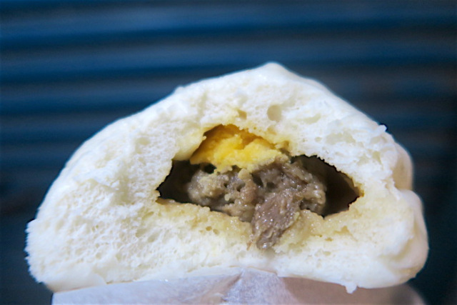A closeup of the inside of Uncle A-shui's famous steamed pork bun with egg yolk